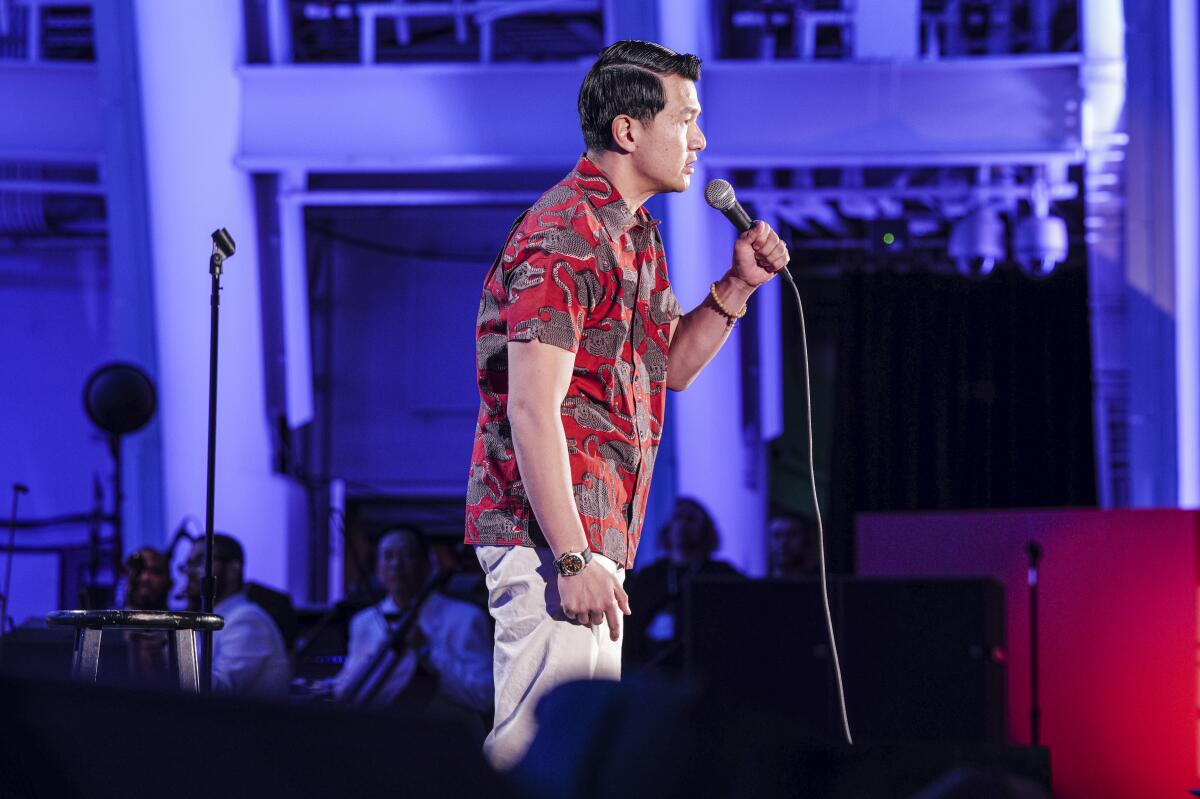 Mann auf der Bühne im roten Hemd mit Mikrofon