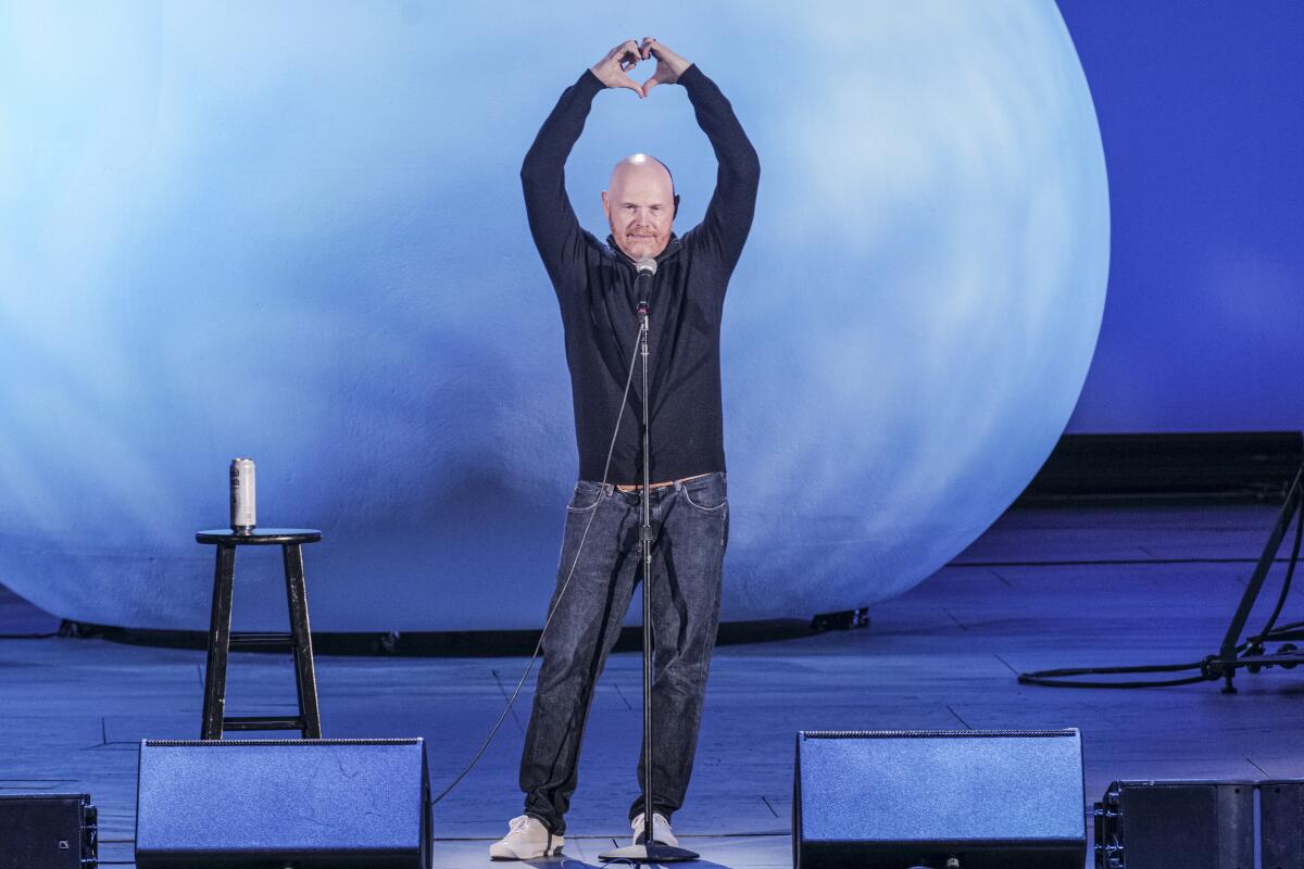 Glatzköpfiger Mann in Hemd und Jeans auf der Bühne mit erhobenen Händen