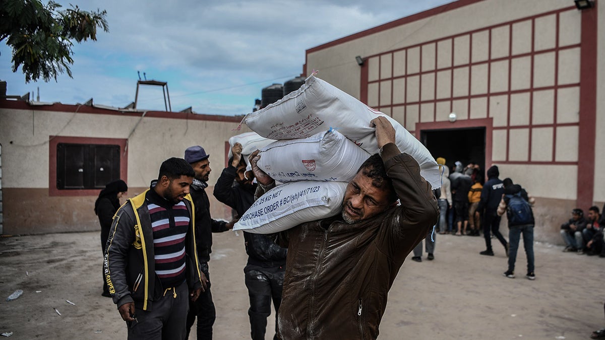 UNRWA-Mehl wird von Bewohnern des Gazastreifens getragen