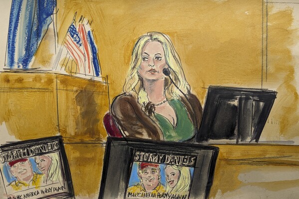 Stormy Daniels sagt im Zeugenstand aus, während am Donnerstag, dem 9. Mai 2024, in New York ein Werbebild für eine ihrer Shows mit einem Bild von Trump auf Monitoren im Strafgerichtshof von Manhattan gezeigt wird.  (Elizabeth Williams über AP)