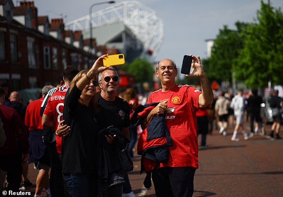 Soccer Football - Premier League - Manchester United v Arsenal - Old Trafford, Manchester, Britain - May 12, 2024 Manchester United fans take a selfie outside the stadium before the match REUTERS/Carl Recine EDITORIAL USE ONLY. NO USE WITH UNAUTHORIZED AUDIO, VIDEO, DATA, FIXTURE LISTS, CLUB/LEAGUE LOGOS OR 'LIVE' SERVICES. ONLINE IN-MATCH USE LIMITED TO 120 IMAGES, NO VIDEO EMULATION. NO USE IN BETTING, GAMES OR SINGLE CLUB/LEAGUE/PLAYER PUBLICATIONS. PLEASE CONTACT YOUR ACCOUNT REPRESENTATIVE FOR FURTHER DETAILS..