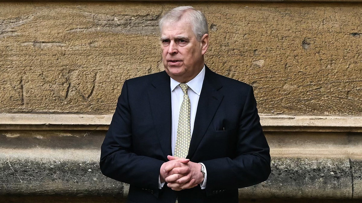 Prince Andrew standing against a wall
