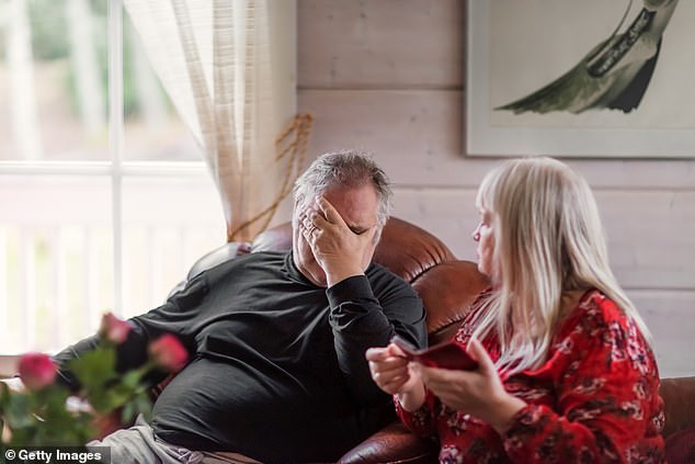 Ein verstörter älterer Mann hat starke Kopfschmerzen, während er zu Hause auf dem Sofa sitzt