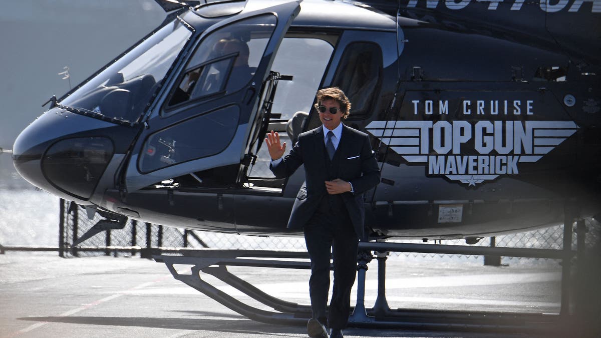 Tom Cruise steigt bei der Premiere von aus einem Hubschrauber "Top Gun: Maverick" im schwarzen Anzug
