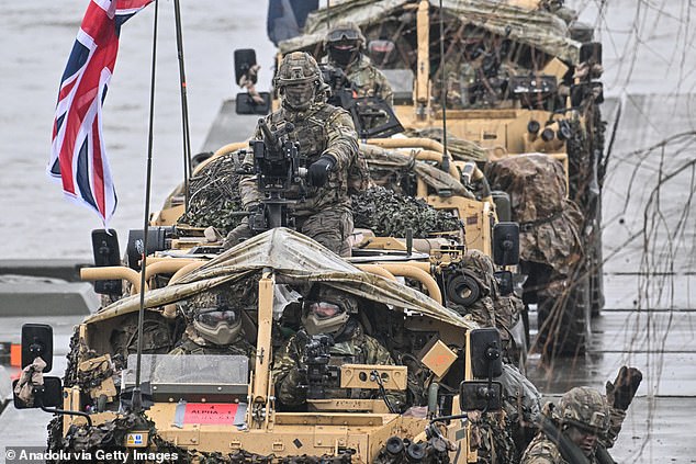 Britische Soldaten stehen in gepanzerten Fahrzeugen, während sie während der NATO-Militärverteidigungsübung DRAGON-24 am 5. März 2024 die Weichsel überqueren