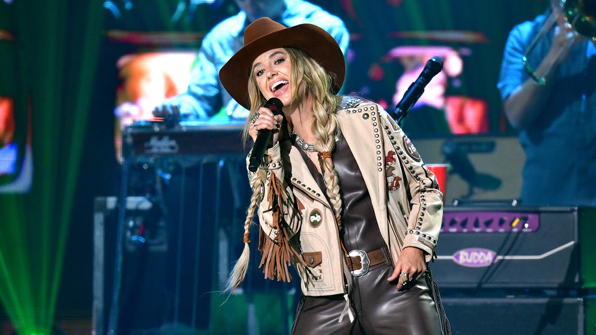Sängerin Lainey Wilson rockt braune Lederhosen und Mantel auf der Bühne der CMT Music Awards.