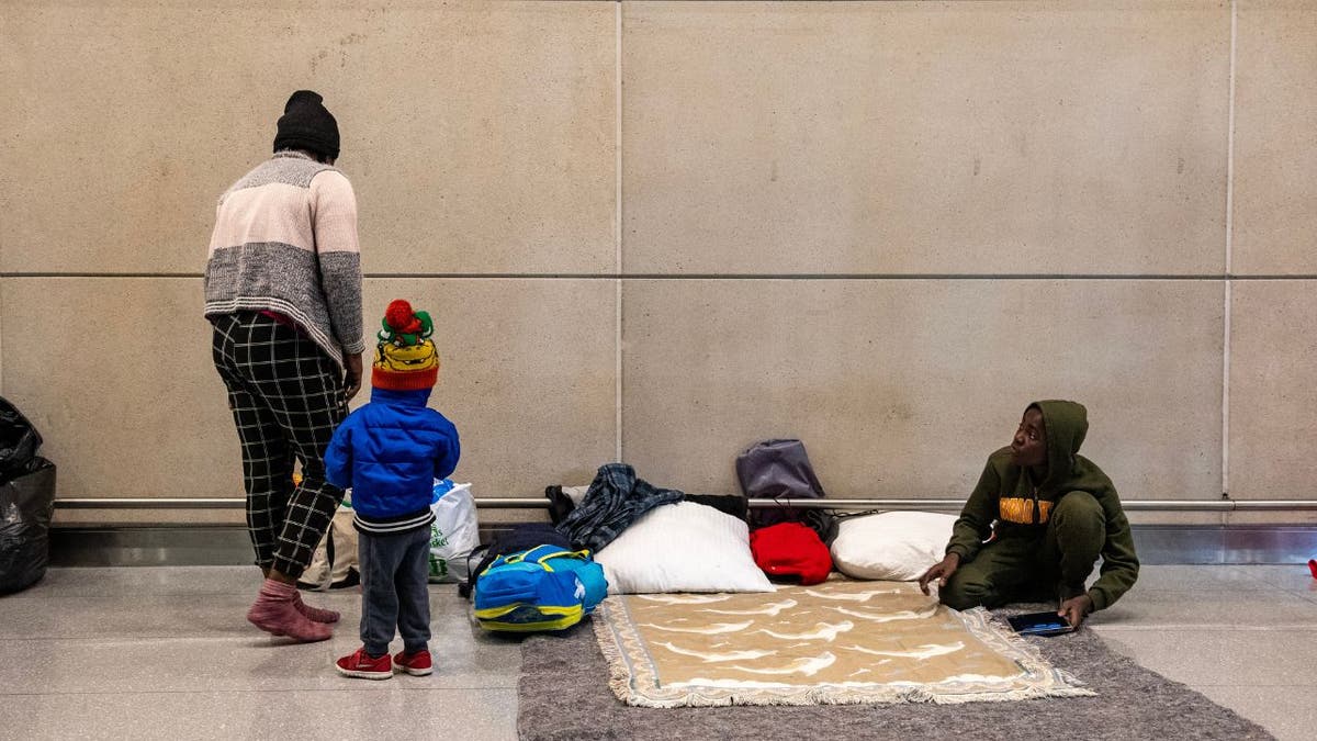 Migranten schlafen am Flughafen Logan