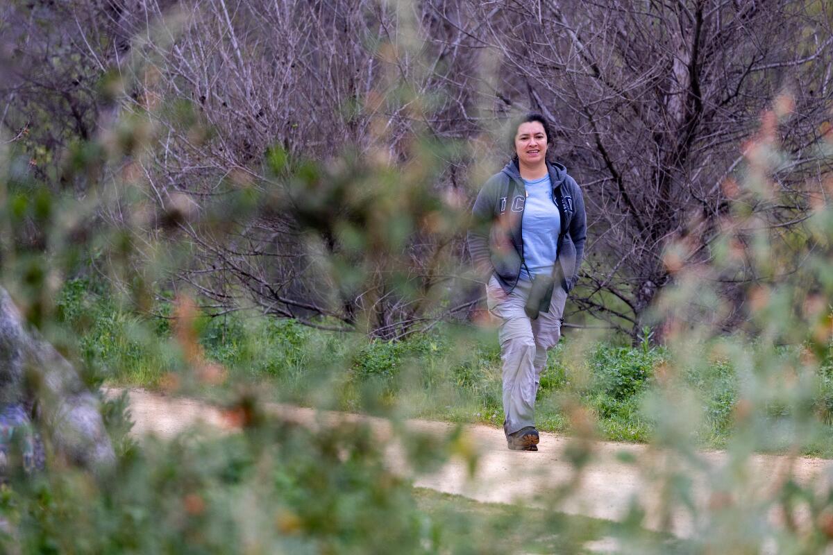 Eine Frau geht einen von Vegetation umgebenen Weg entlang