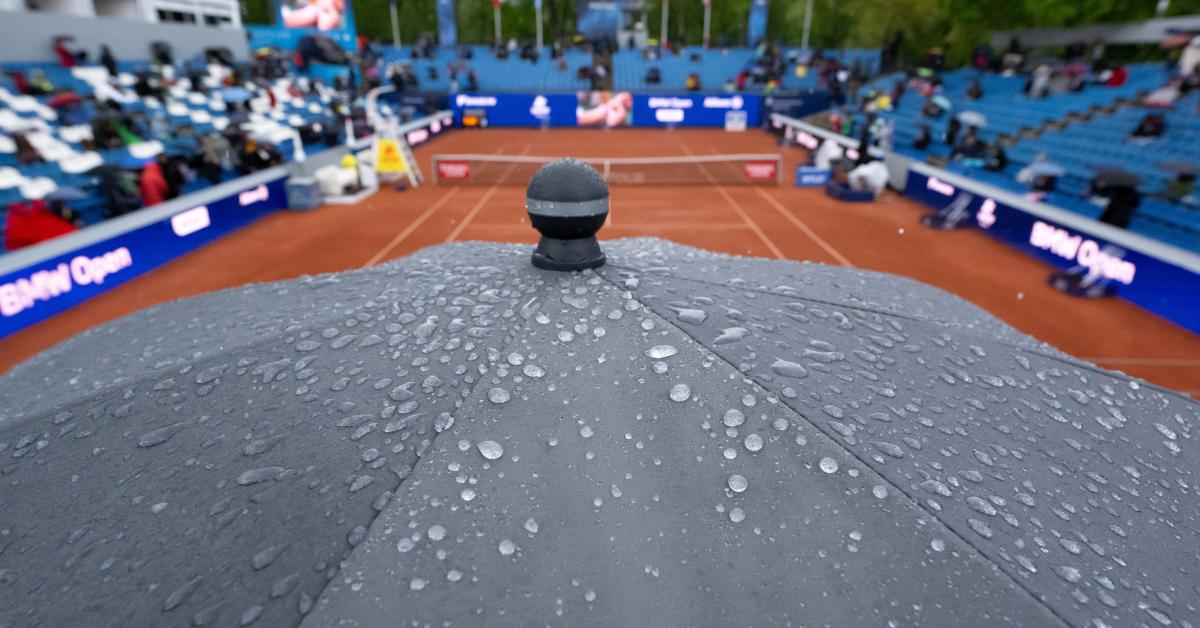 Ein nasser Regenschirm bei einem wetterbedingt unterbrochenen Tennisspiel