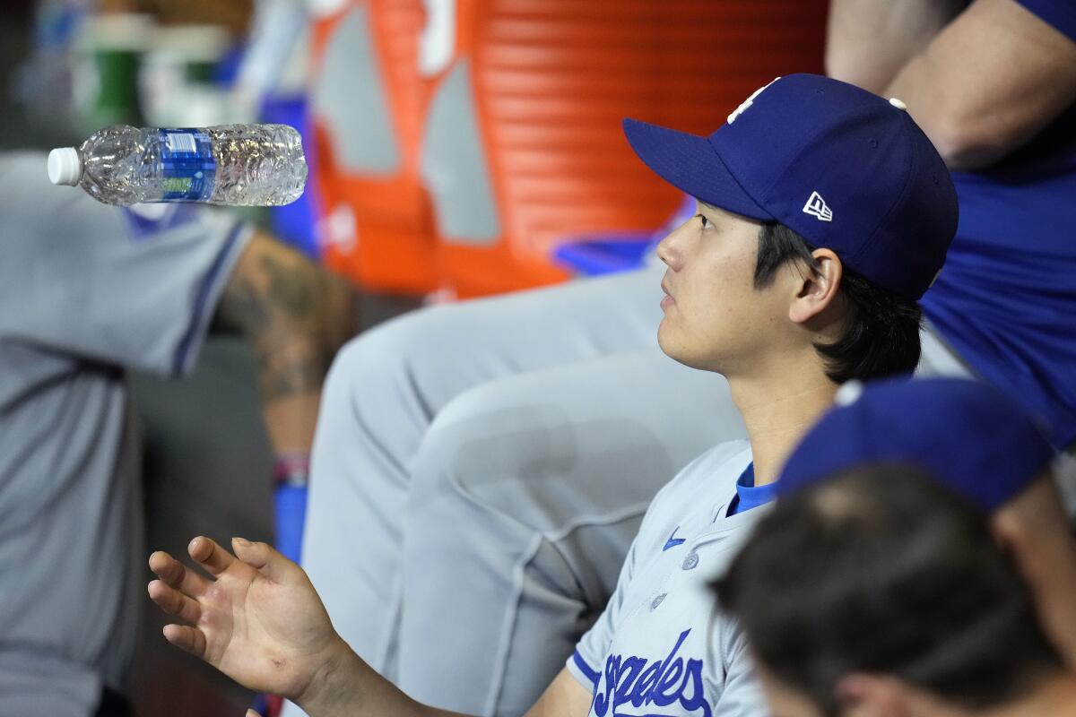 Shohei Ohtani wirft während des Spiels am Mittwoch gegen die Diamondbacks eine Wasserflasche in die Luft, während er auf der Bank sitzt.