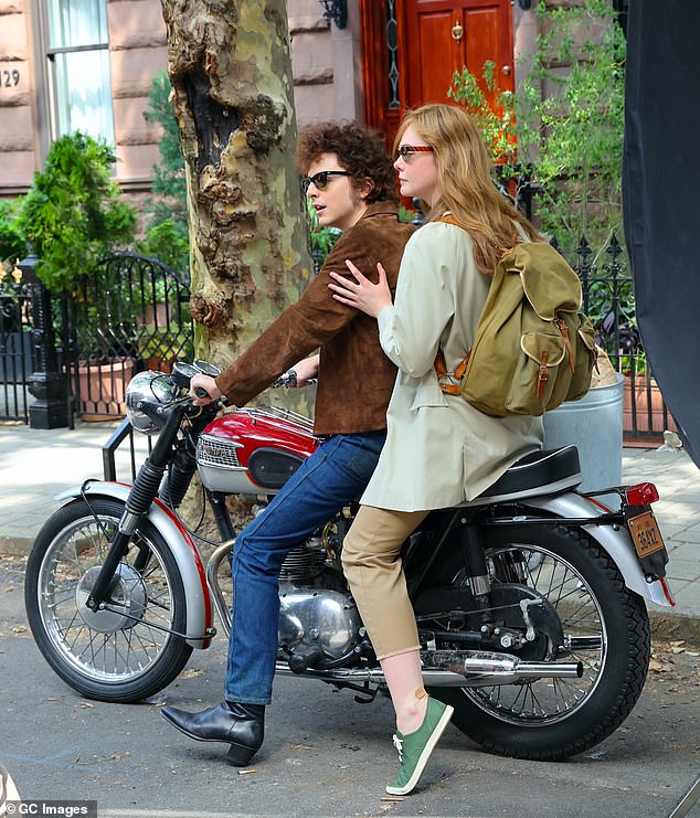 Fanning, die Suze Rotolo spielt, Dylans Freundin von 1961 bis 1964, trug eine beige Jacke, abgeschnittene Khakihosen, grüne Turnschuhe und einen großen Rucksack, als sie Chalamet zur Unterstützung festhielt.