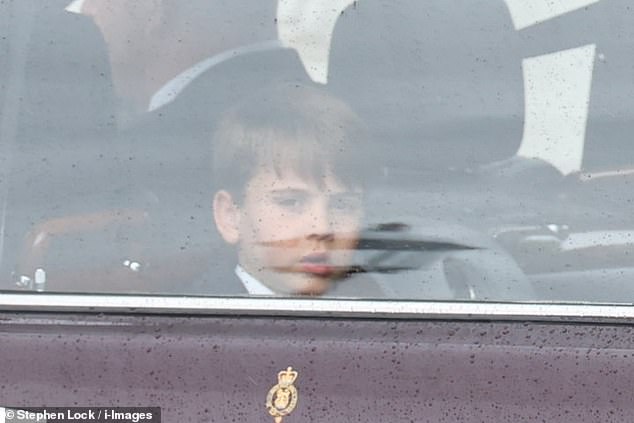 Prince Louis looks out from the window of the car as the family enter Buckingham Palace today