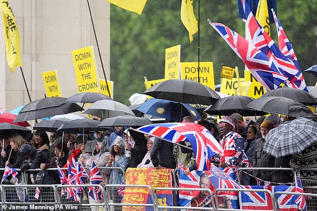 Protesters and royal fans hold umbrellas on the The Mall before Trooping the Colour today