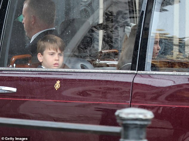 Prince Louis looks out from the window of the car as the family enter Buckingham Palace today