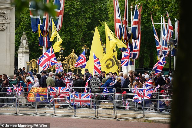 Protesters wave banners on the The Mall ahead of the Trooping the Colour ceremony today