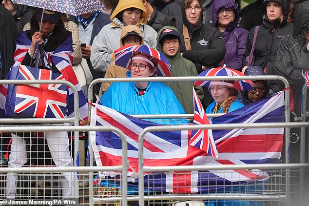 Royal fans stand on The Mall in London ahead of Trooping the Colour this morning