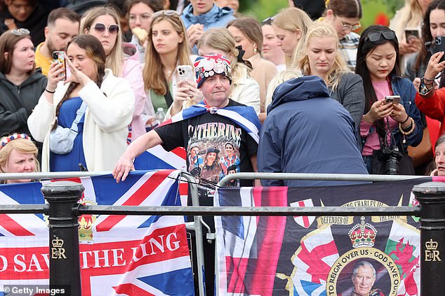 Royal fans stand on The Mall in London ahead of Trooping the Colour this morning