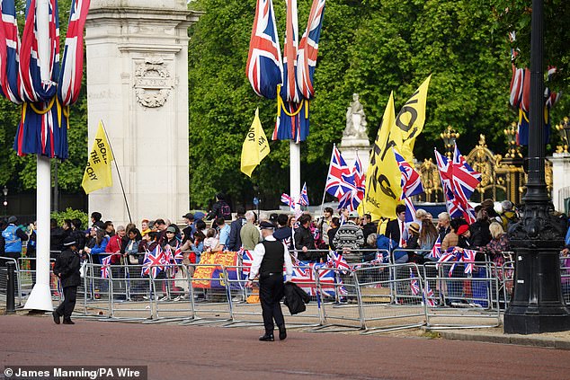 Protesters wave banners on the The Mall ahead of the Trooping the Colour ceremony today