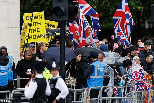 Police look on as anti-monarchist protesters wave flags next to royal fans in London today