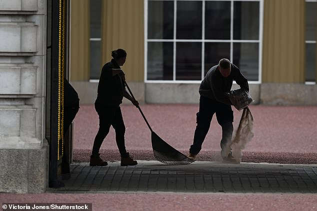 Staff lay more gravel of the forecourt of Buckingham Palace in preparation this morning