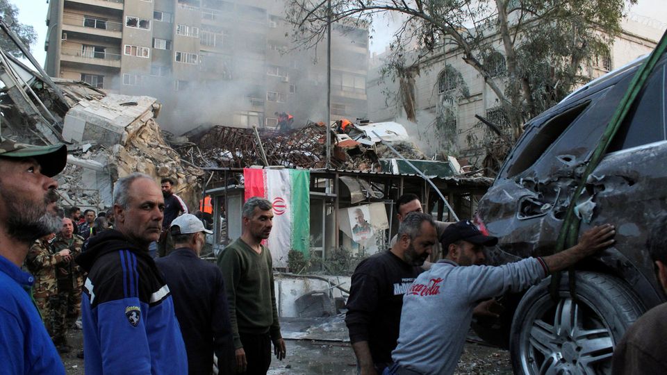The Iranian consulate in Syria's capital Damascus after the attack on Monday afternoon.  A picture of Quds Force General Qassem Soleimani, who was killed in 2020, hangs on the destroyed building next to an Iranian flag