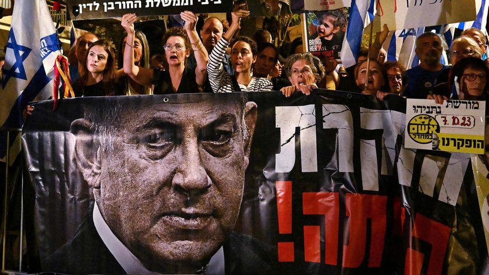 Protesters with a large banner demand Netanyahu's resignation