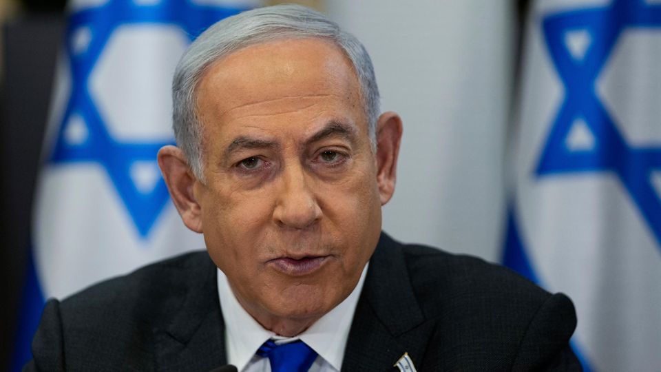 Benjamin Netanyahu in front of Israel flags