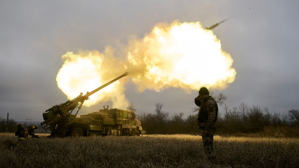 Ukrainian soldiers fire a howitzer at Russian positions