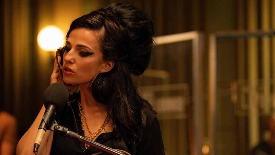 Marisa Abela as Amy Winehouse in "Back to Black" sings into a microphone