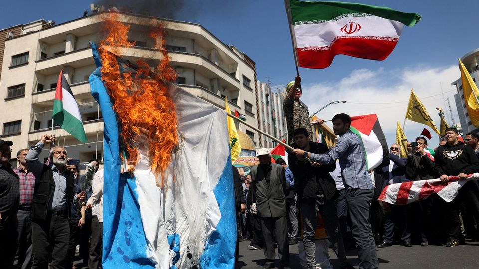 Iranian protesters burn an Israeli flag in Tehran