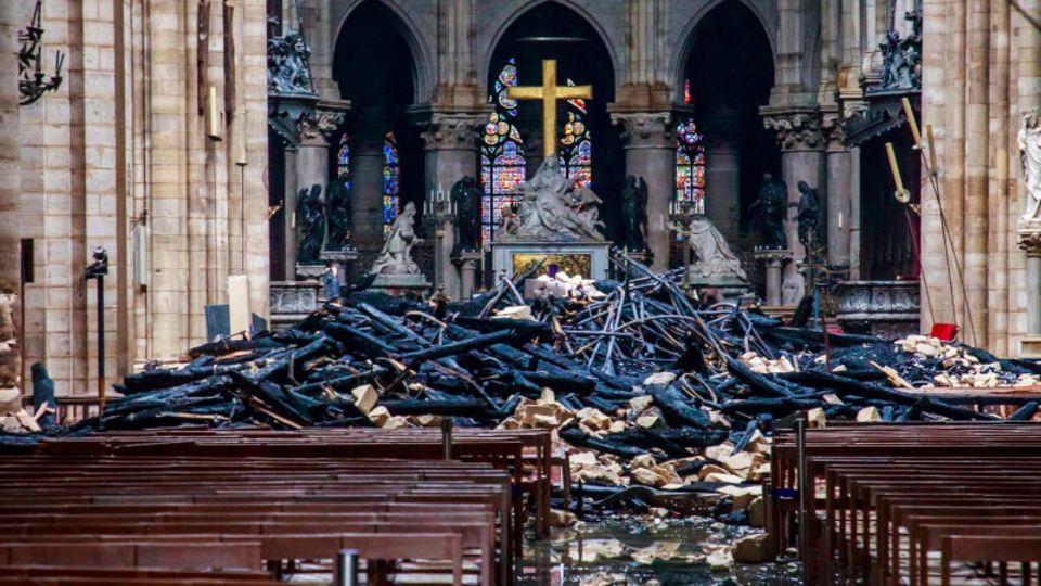 The Notre Dame after the fire in 2019, there are rubble and charred wooden beams in the church