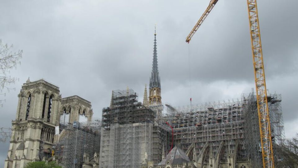 The Notre Dame, covered in scaffolding, with a crane next to it