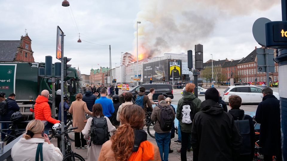 People watch fire and smoke coming out of the "Børsen" rising up