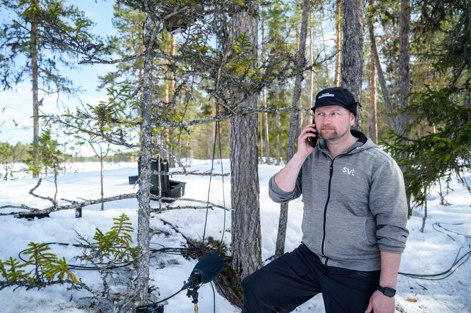 Stefan Edlund, Produzent des schwedischen Fernsehsenders SVT in Umeå, steht im verschneiten Wald und telefoniert.
