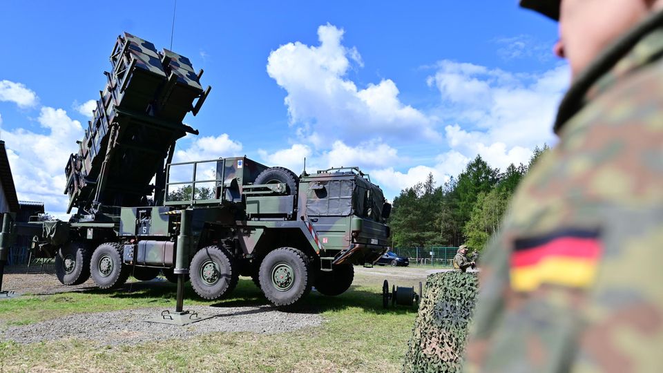 A Bundeswehr soldier stands next to the Patriot air defense system during an exercise.