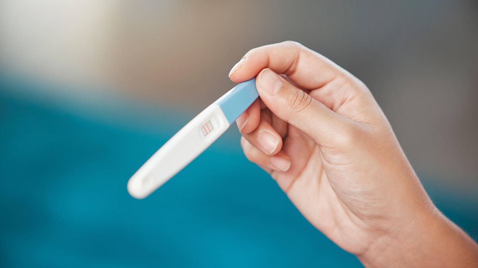 Abortion: A person holds a positive pregnancy test