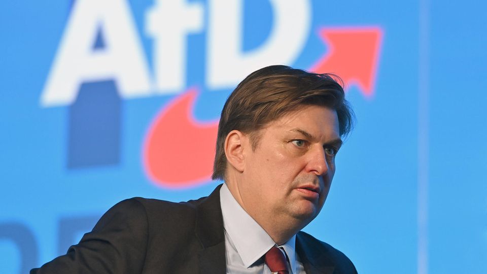 Maximilian Krah stands in front of a poster of his AFD party