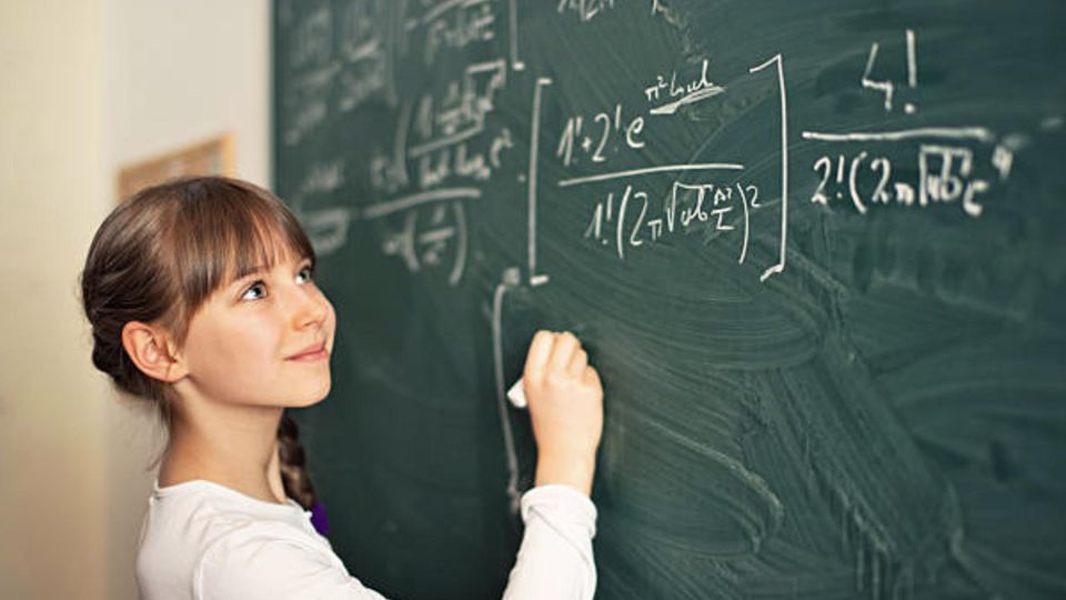 A girl is standing at the blackboard