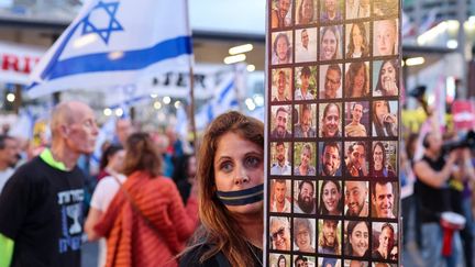 A protester holds portraits of Israeli hostages during a rally to demand their release, April 27, 2024, in Tel Aviv (Israel).  (JACK GUEZ / AFP)