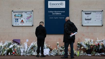 Two people pray in front of Les Sablons college in Viry-Châtillon (Essonne), April 7, 2024. (EMMANUEL DUNAND / AFP)