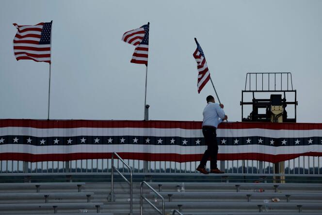 Staff members remove American flags after a Donald Trump rally in Wilmington, North Carolina, was postponed on April 20, 2024.