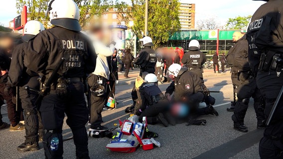 Police officers and paramedics look after an injured person.  He fell during a police operation during a May demonstration at Hamburg's Schlump subway station.  © HamburgNews Photo: HamburgNews