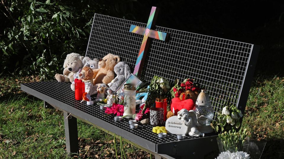 Mourners have placed candles, flowers and stuffed animals, among other things, on a bench by a lake in Pragsdorf