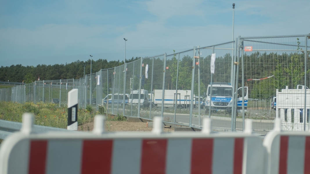 The Tesla factory in Grünheide is cordoned off with fences all around.  Police forces are right behind them.