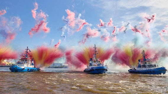Tugboats shoot bright colors into the sky.  © picture alliance/dpa Photo: Georg Wendt