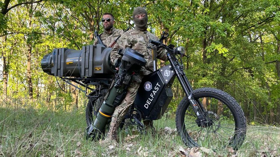 A Delfast e-bike carrying two Ukrainian army soldiers and a mounted anti-tank guided missile